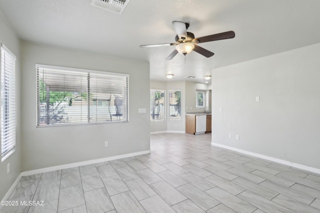 spare room featuring baseboards, ceiling fan, and visible vents