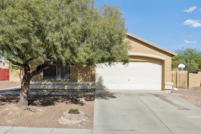 7351 S Bass Ave, Tucson, AZ 85746 - view of property hidden behind natural elements featuring stucco siding, concrete driveway, and an attached garage