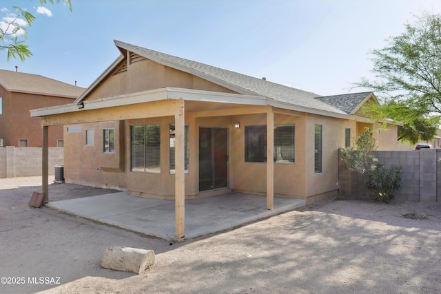 back of house featuring a patio, roof with shingles, fence, and stucco siding
