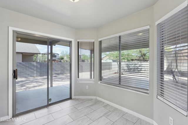unfurnished room with baseboards and light tile patterned floors