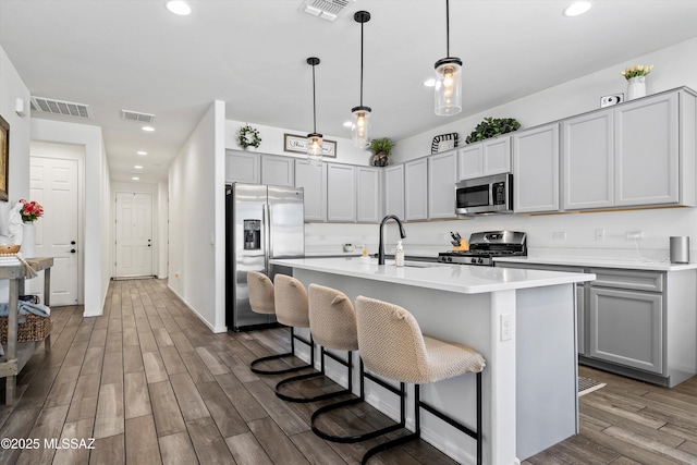 kitchen with visible vents, wood finished floors, and stainless steel appliances