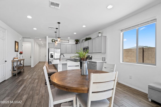 dining area with baseboards, recessed lighting, wood finished floors, and visible vents