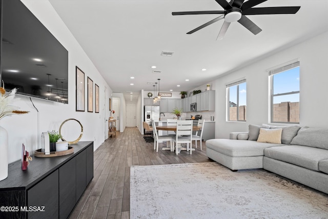 living room featuring visible vents, recessed lighting, ceiling fan, and wood finished floors