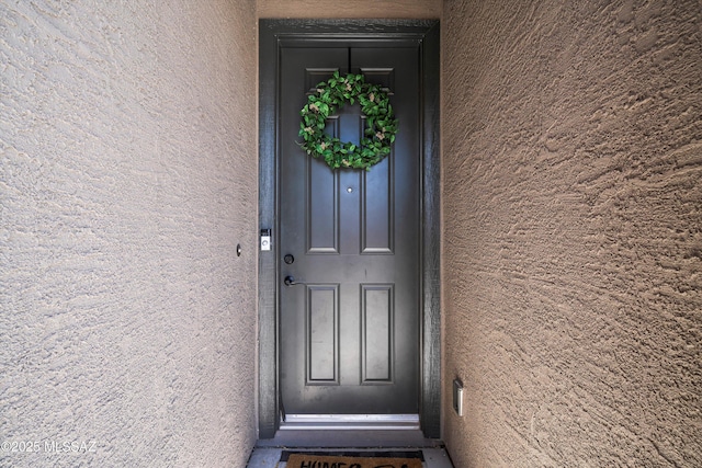 property entrance featuring stucco siding