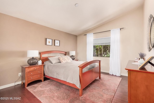 bedroom with vaulted ceiling, wood finished floors, and baseboards