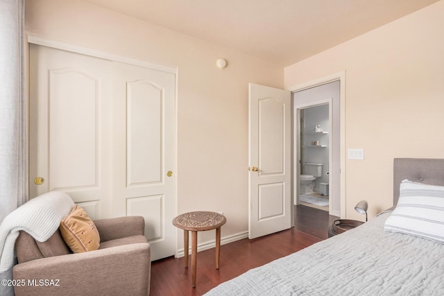 bedroom with dark wood-type flooring, a closet, and baseboards