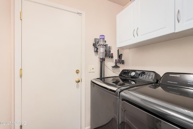 laundry room featuring washing machine and clothes dryer and cabinet space