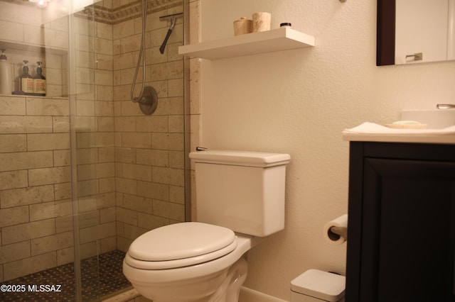 bathroom featuring toilet, a shower stall, and vanity