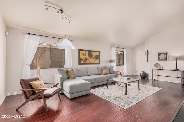 living room featuring dark wood finished floors, baseboards, and lofted ceiling