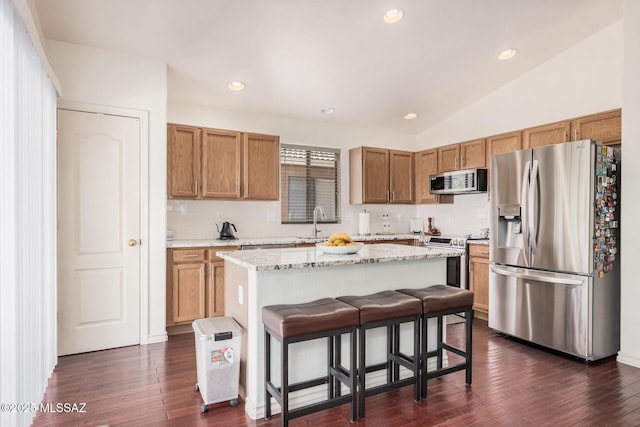 kitchen with appliances with stainless steel finishes, backsplash, dark wood-style flooring, recessed lighting, and lofted ceiling