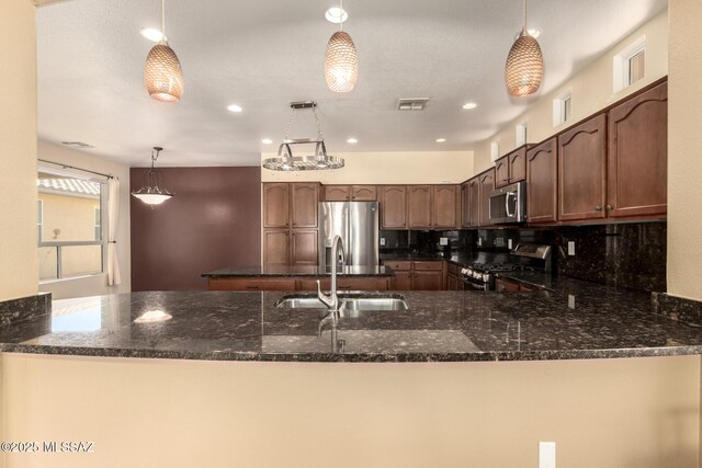 2436 E Desert Pueblo Pass, Green Valley, AZ 85614 - kitchen with visible vents, a sink, a peninsula, dark stone counters, and stainless steel appliances