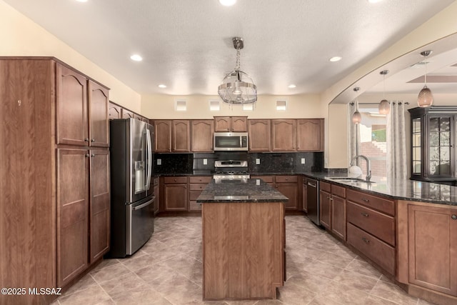 2436 E Desert Pueblo Pass, Green Valley, AZ 85614 - kitchen with a sink, dark stone countertops, stainless steel appliances, a peninsula, and tasteful backsplash