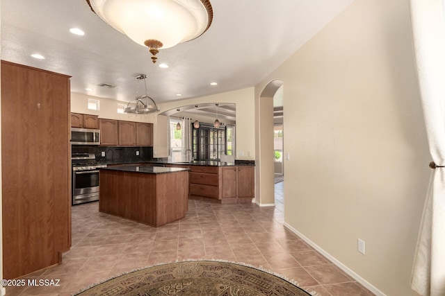 2436 E Desert Pueblo Pass, Green Valley, AZ 85614 - kitchen with a kitchen island, dark countertops, recessed lighting, arched walkways, and appliances with stainless steel finishes