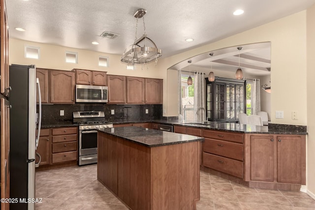 2436 E Desert Pueblo Pass, Green Valley, AZ 85614 - kitchen featuring visible vents, decorative backsplash, a kitchen island, a sink, and appliances with stainless steel finishes