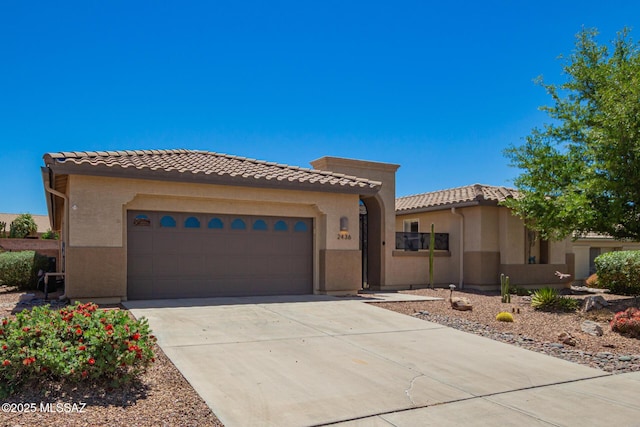 2436 E Desert Pueblo Pass, Green Valley, AZ 85614 - mediterranean / spanish-style home featuring an attached garage, stucco siding, driveway, and a tile roof