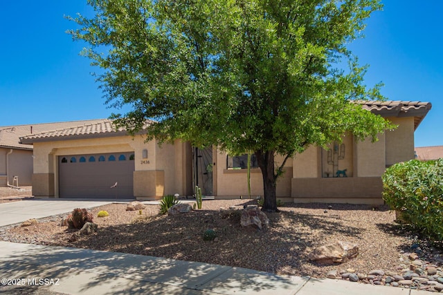 2436 E Desert Pueblo Pass, Green Valley, AZ 85614 - view of front of home featuring concrete driveway, a tiled roof, an attached garage, and stucco siding