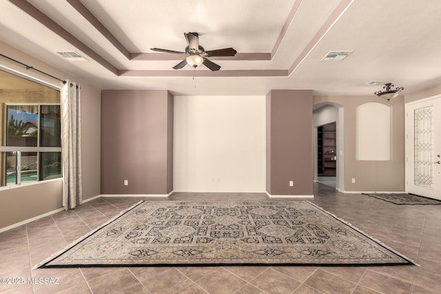 2436 E Desert Pueblo Pass, Green Valley, AZ 85614 - unfurnished room with visible vents, arched walkways, tile patterned floors, a tray ceiling, and a ceiling fan