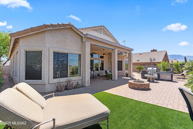 39930 S Mountain Shadow Dr, Tucson, AZ 85739 - view of patio / terrace with ceiling fan, an outdoor kitchen, and an outdoor living space with a fire pit