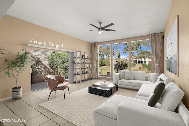 living area with baseboards, a ceiling fan, and light tile patterned flooring