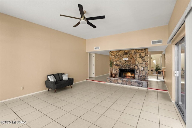 unfurnished living room featuring visible vents, baseboards, ceiling fan, and a stone fireplace
