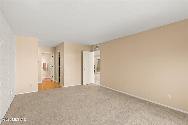unfurnished room featuring baseboards, visible vents, and carpet
