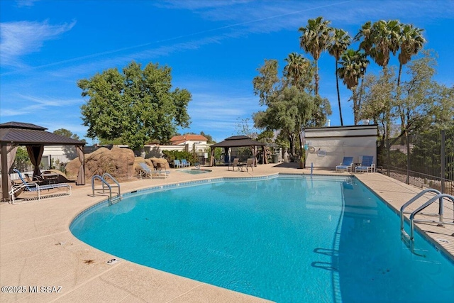 community pool with a gazebo, fence, and a patio