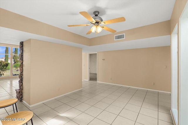 spare room featuring ceiling fan, baseboards, visible vents, and light tile patterned floors