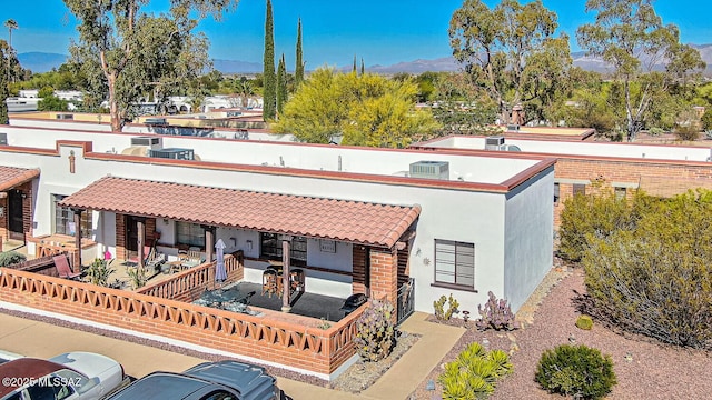rear view of property featuring a mountain view and stucco siding
