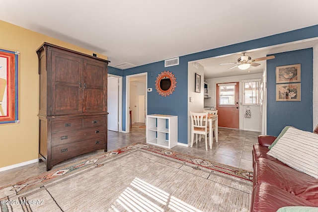 living room with visible vents, baseboards, ceiling fan, and light tile patterned floors