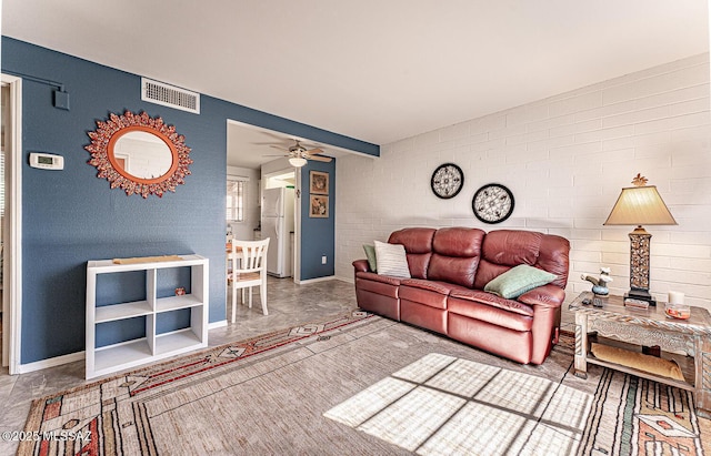 living area with a ceiling fan, baseboards, and visible vents
