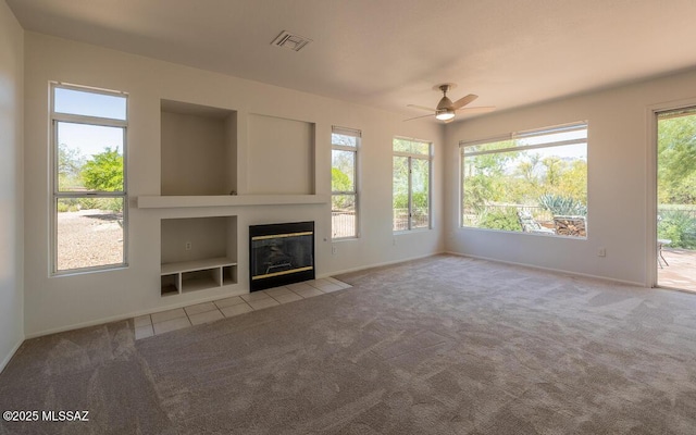 1448 E Mule Train Dr, Oro Valley, AZ 85755 - unfurnished living room with a ceiling fan, baseboards, built in shelves, and carpet