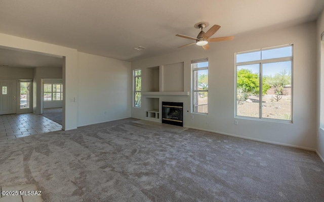 1448 E Mule Train Dr, Oro Valley, AZ 85755 - unfurnished living room featuring a ceiling fan, baseboards, a glass covered fireplace, and carpet