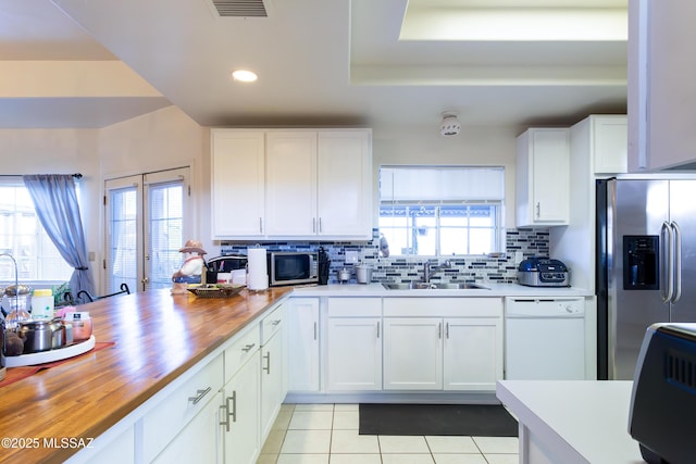 21 Kachina, Rio Rico, AZ 85648 - kitchen featuring decorative backsplash, appliances with stainless steel finishes, a sink, butcher block counters, and light tile patterned flooring