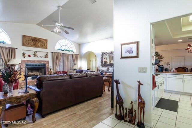21 Kachina, Rio Rico, AZ 85648 - living room featuring plenty of natural light, ceiling fan, arched walkways, a fireplace, and lofted ceiling