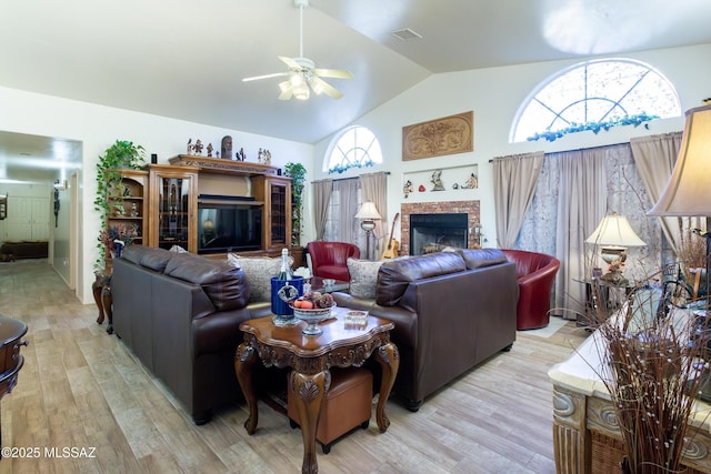 21 Kachina, Rio Rico, AZ 85648 - living room featuring visible vents, a fireplace, light wood-style floors, ceiling fan, and high vaulted ceiling