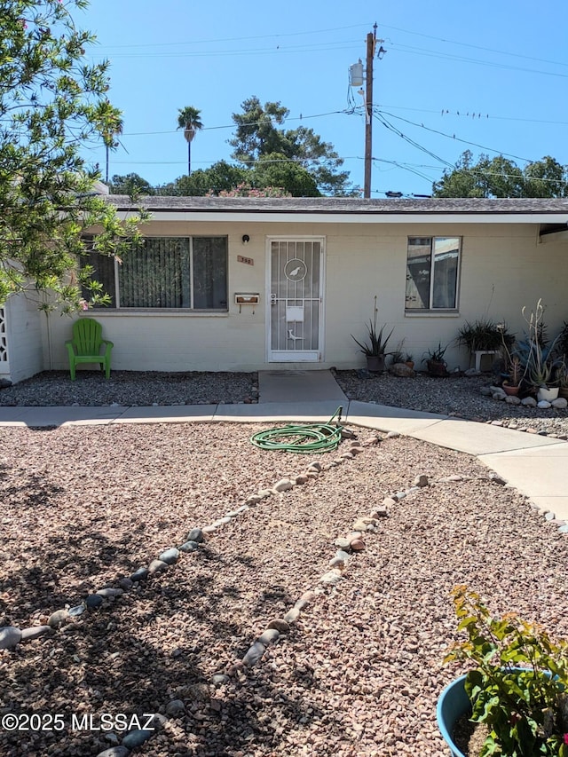 view of front of home with a shingled roof and concrete block siding