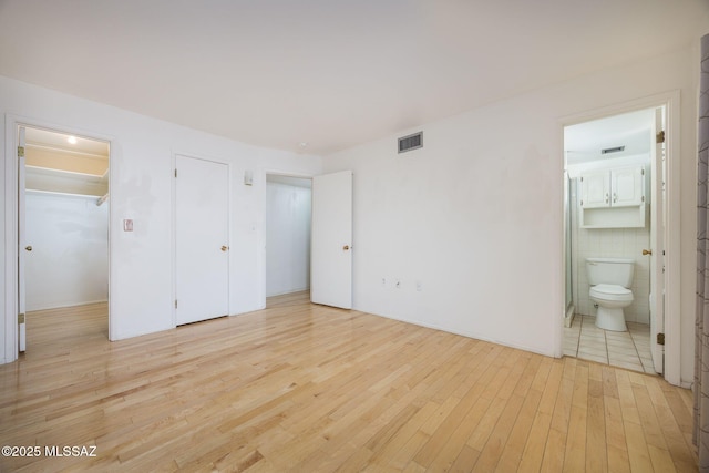 390 N Silverbell Rd, Tucson, AZ 85745 - unfurnished bedroom with light wood-style floors and ensuite bath