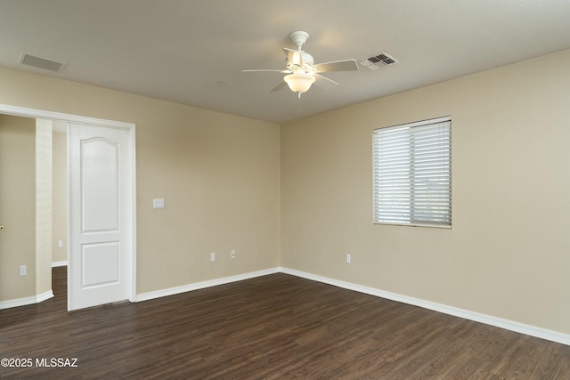 spare room with ceiling fan, dark wood-style flooring, and visible vents