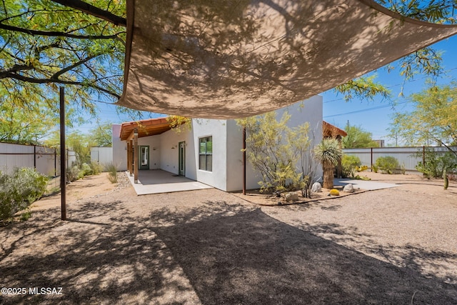 back of house with a patio, a fenced backyard, and stucco siding