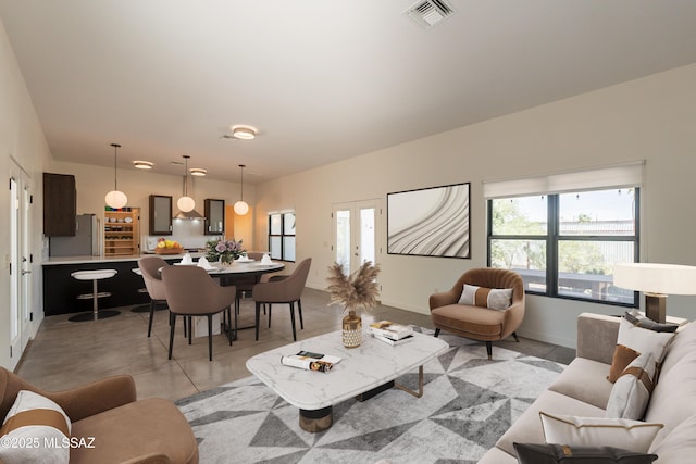living area with baseboards, french doors, and visible vents
