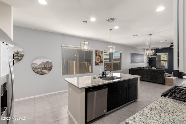 7688 S Via Perfecta, Tucson, AZ 85756 - kitchen with stainless steel appliances, a sink, recessed lighting, light stone counters, and dark cabinetry