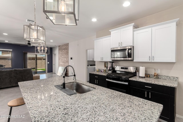 7688 S Via Perfecta, Tucson, AZ 85756 - kitchen with stainless steel appliances, a sink, a center island with sink, white cabinetry, and open floor plan
