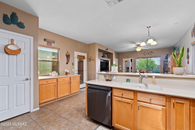kitchen featuring dishwashing machine, light tile patterned floors, a sink, and a healthy amount of sunlight