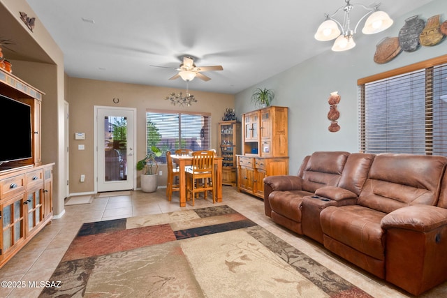 living room with baseboards, ceiling fan with notable chandelier, and light tile patterned flooring
