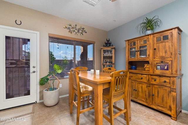 dining space with baseboards, a ceiling fan, light tile patterned flooring, and visible vents