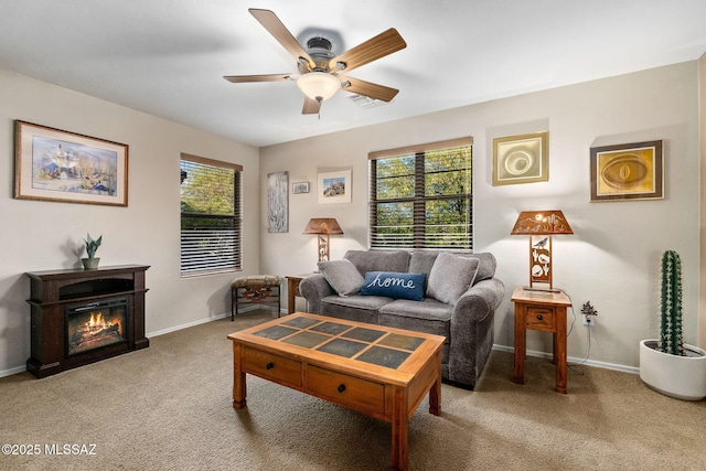 living area featuring plenty of natural light, carpet flooring, baseboards, and ceiling fan