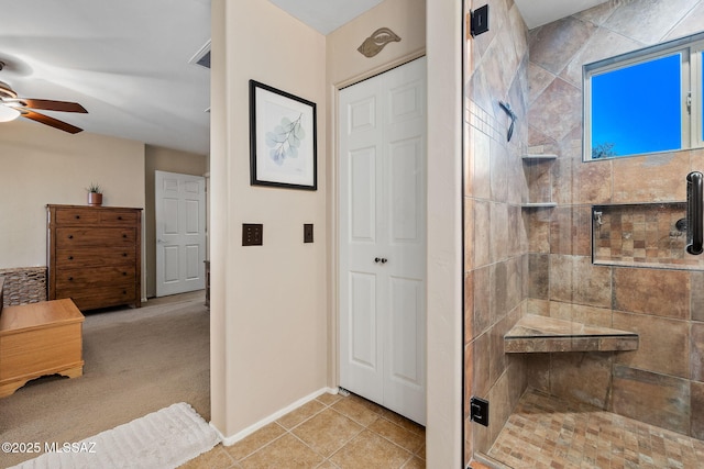 bathroom with a ceiling fan, baseboards, and a stall shower