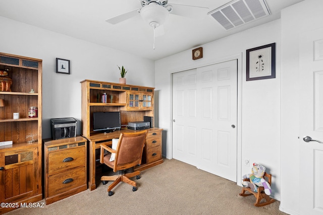 carpeted office featuring visible vents and a ceiling fan
