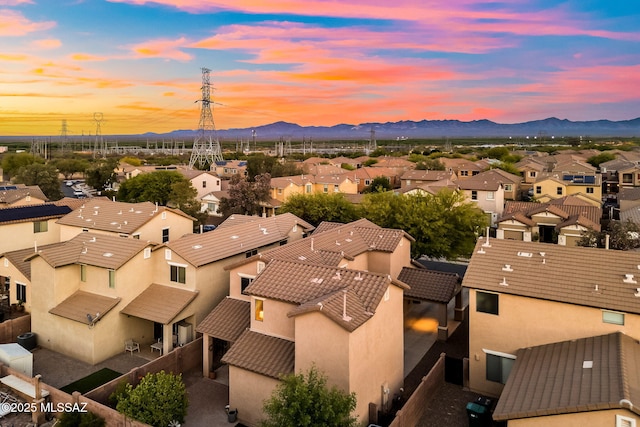 aerial view at dusk featuring a residential view and a mountain view