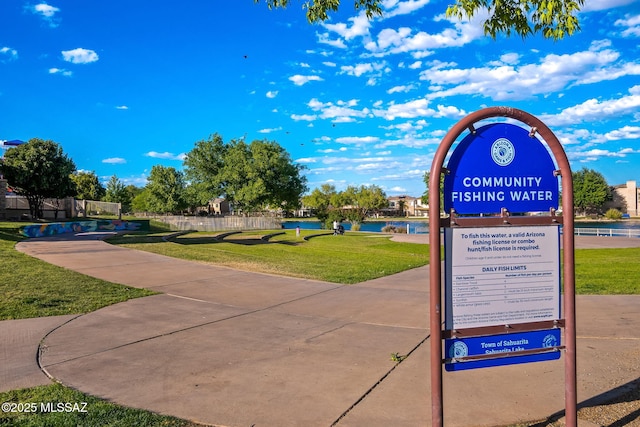 surrounding community with a lawn and a water view